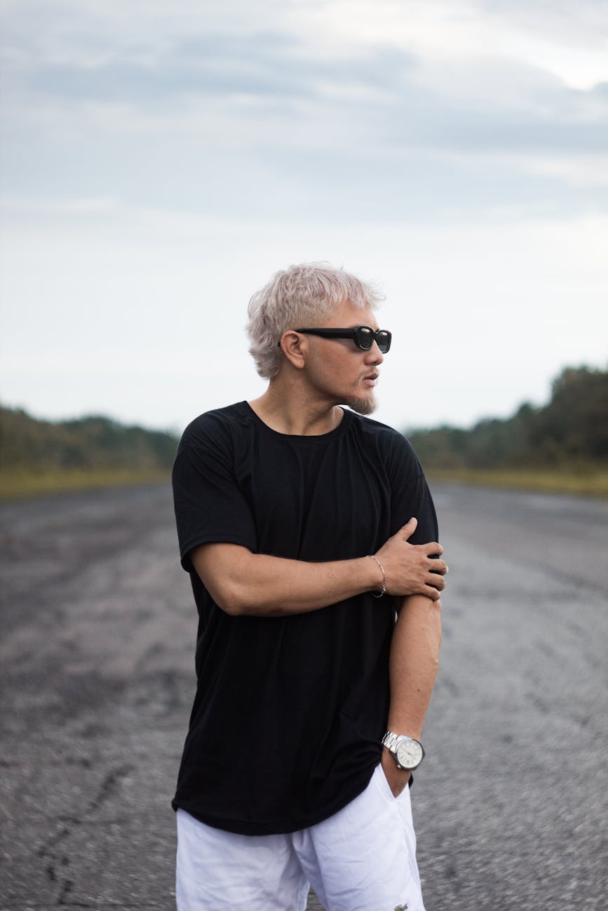 young man with dyed blond hair standing outside